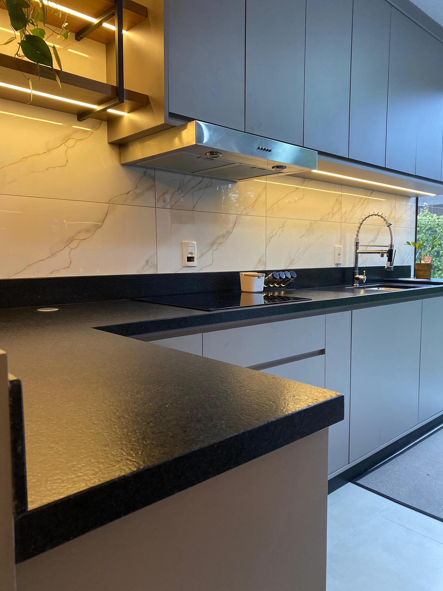 Referência de cozinha com bancada escura e armários